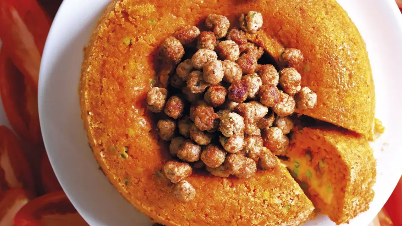 Tortino arancione ripieno, con polpettine al centro. Un classico dei primi piatti della domenica, invitante e saporito.