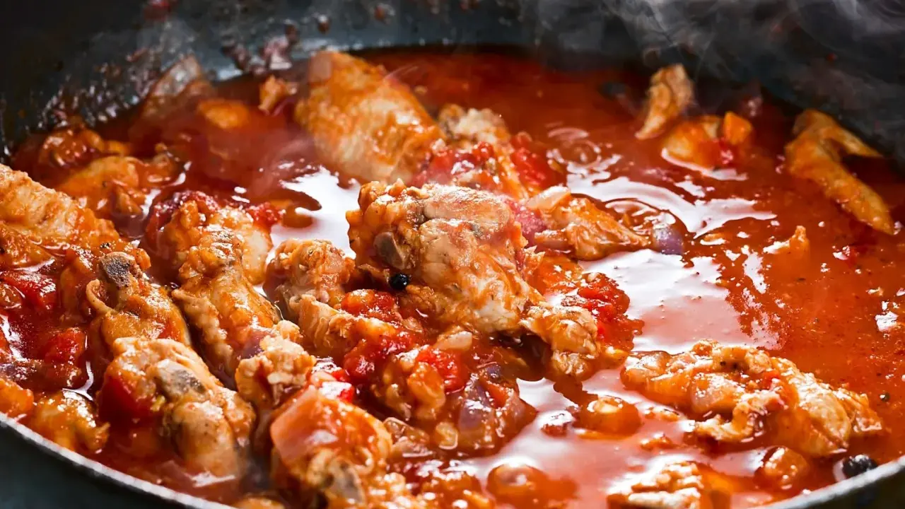 Succulenta carne alla pizzaiola che sobbolle in padella, sprigionando un profumo invitante. Pezzi di carne tenera immersi in un sugo rosso ricco di pomodoro e spezie.
