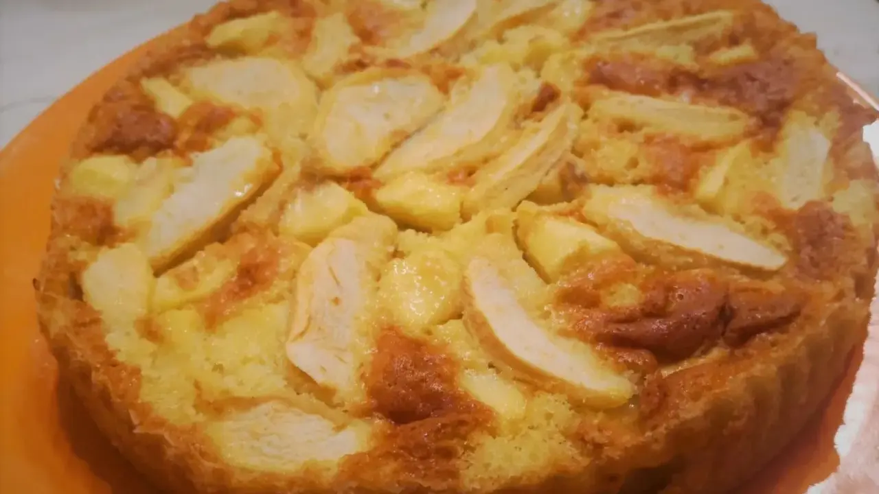 Una torta di mele dorata e soffice, con fette di mela caramellate in superficie. Probabilmente la torta di mele più buona che abbia mai mangiato.