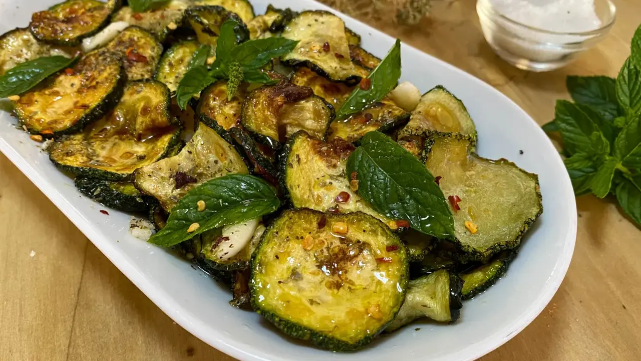 Zucchine alla scapece dorate e condite con menta fresca, aglio e peperoncino. Un contorno saporito e colorato.