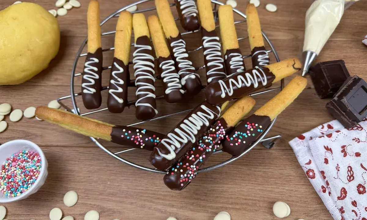 Biscotti al cioccolato decorati con glassa bianca e zuccherini colorati, pronti per essere gustati.