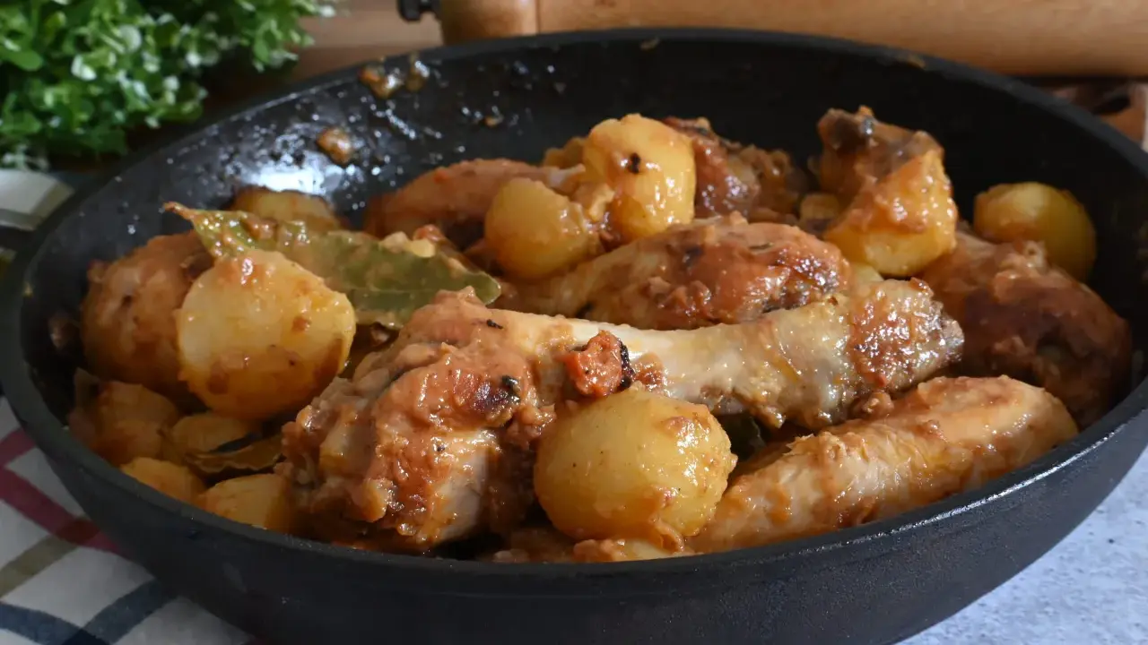 Un saporito pollo in umido con patate e alloro, cotto in padella.