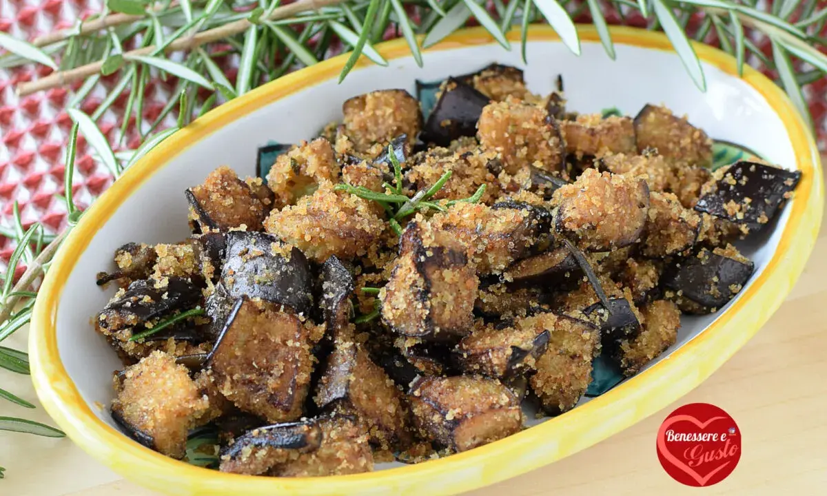 Melanzane in padella con pangrattato, croccanti e dorate, guarnite con rosmarino fresco. Un contorno saporito e invitante.
