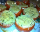 Pomodori gratinati al forno, ripieni di pangrattato e erbe aromatiche, pronti per essere gustati.