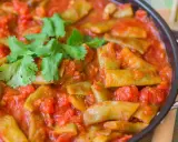 Taccole al pomodoro cotte in padella, guarnite con prezzemolo fresco. Un piatto semplice e gustoso.