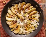 Finoçchi gratinati in padella, dorati e saporiti, guarniti con scaglie di formaggio e noci croccanti.