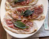 Saltimbocca alla romana: fettine di vitello con prosciutto crudo e salvia, condite con olio e pepe.