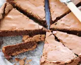 Una deliziosa torta al cioccolato, tagliata a fette triangolari, mostra la sua consistenza umida e ricca.