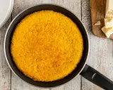 Un invitante riso al salto dorato in padella, pronto per essere gustato con scaglie di Parmigiano Reggiano.