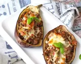 Melanzane ripiene al forno velocissime, con un saporito ripieno e formaggio filante, guarnite con basilico fresco.