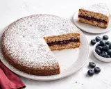 Torta senza glutine con marmellata di frutti di bosco, spolverata di zucchero a velo, accompagnata da mirtilli freschi.