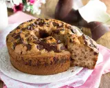 Ciambellone soffice con gocce di cioccolato, perfetto per la colazione di Pasqua, con uova di Pasqua sullo sfondo.