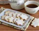 Biscotti con farina di riso a forma di fiore, spolverati di zucchero a velo, serviti con una tazza di tè.