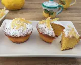 Deliziosi muffin caprese al limone, spolverati di zucchero a velo e decorati con scorzette candite.