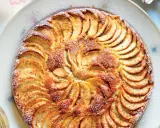 Una deliziosa torta di mele, con fette disposte a raggiera e una spolverata di zucchero a velo.