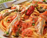 Spaghetti con sugo di pomodoro, acciughe intere e un peperoncino rosso piccante. Un piatto di pasta semplice e saporito.