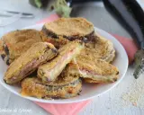 Cordon bleu di melanzane impanati e fritti, ripieni di prosciutto e formaggio filante, serviti su un piatto bianco.