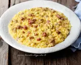 Un cremoso risotto con salsiccia, servito su un piatto bianco, pronto per essere gustato.