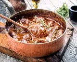 Un saporito brasato di manzo, cotto lentamente in una pentola di rame, guarnito con timo fresco.