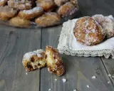 Frittelle di riso ricetta della nonna: dolcetti dorati e zuccherati, alcuni su un piatto, altri su un pizzo, uno aperto rivela l'interno morbido.