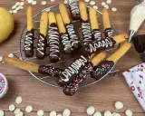 Biscotti al cioccolato decorati con glassa bianca e zuccherini colorati, pronti per essere gustati.