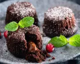 Tre tortini al cioccolato con cuore fondente, guarniti con menta e frutti rossi, spolverati di zucchero a velo.
