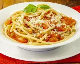 Un piatto invitante di pasta alla carrettiera, con pomodoro fresco, basilico e abbondante formaggio grattugiato.