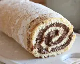 Un soffice rotolo alla Nutella, cosparso di zucchero a velo, pronto per essere gustato.