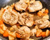 Porzioni di ossobuco di tacchino cotte in padella con patate e carote a cubetti, condite con erbe aromatiche.
