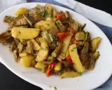 Deliziosi carciofi e patate in padella, un contorno saporito e colorato, arricchito da pomodorini e prezzemolo fresco.