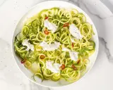 Spaghetti di zucchine freschi con ricotta cremosa, peperoncino e menta, un piatto leggero e colorato.