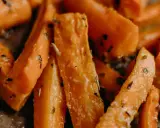 Carote in padella, tagliate a bastoncino e condite con erbe aromatiche, pronte per essere gustate.