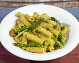 Piatto di pasta con asparagi e salsiccia, condita con una cremosa salsa verde.