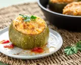 Zucchine ripiene in padella, un piatto gustoso e colorato, guarnito con prezzemolo fresco e servito su un piatto rustico.