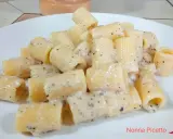 Piatto di rigatoni cremosi conditi con un classico cacio e pepe, pronti per essere gustati.