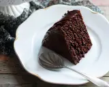 Una fetta di ciambellone al cioccolato, soffice e golosa, su un piatto bianco con un cucchiaino d'argento.
