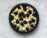 Mele a cubetti e more in una teglia nera, pronte per un delizioso crumble di mele.
