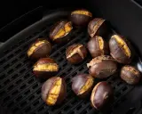Castagne arrostite nella friggitrice ad aria, con la buccia aperta che rivela il loro interno dorato e invitante.