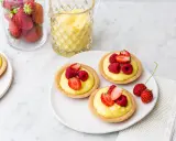 Deliziose tartellette alla frutta con crema pasticcera e frutti di bosco freschi, pronte per essere gustate.