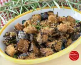Melanzane in padella con pangrattato, croccanti e dorate, guarnite con rosmarino fresco. Un contorno saporito e invitante.