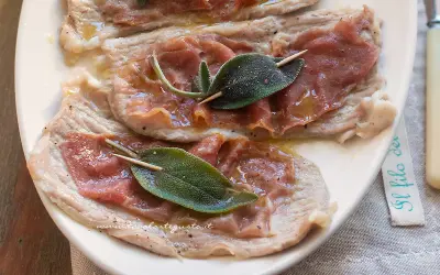Saltimbocca alla romana: fettine di vitello con prosciutto crudo e salvia, condite con olio e pepe.