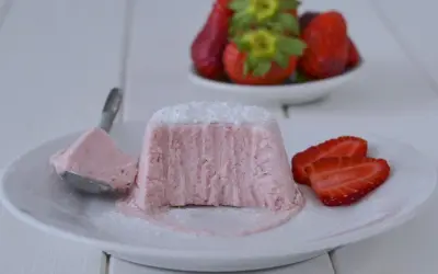 Delizioso semifreddo alle fragole, con una fetta servita su un cucchiaino e guarnito con zucchero a velo e fragole fresche.