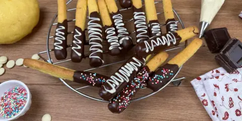 Biscotti al cioccolato decorati con glassa bianca e zuccherini colorati, pronti per essere gustati.