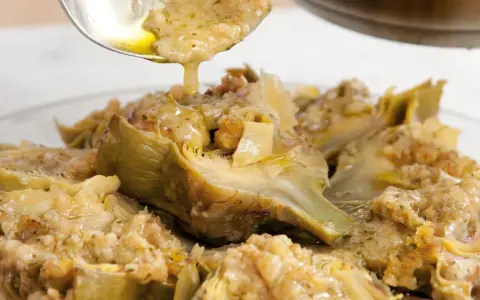 Carciofi alla romana ricetta: carciofi stufati con un condimento saporito, pronti per essere gustati.