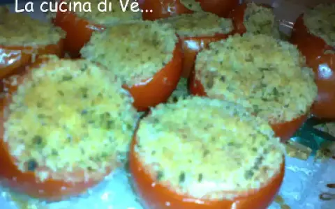 Pomodori gratinati al forno, ripieni di pangrattato e erbe aromatiche, pronti per essere gustati.