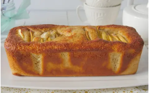 Plumcake alle mele dorato e soffice, con mele a vista in superficie, pronto per essere gustato.
