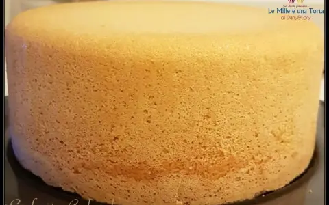 Un pan di spagna sofficissimo, dorato e invitante, pronto per essere farcito. La sua consistenza perfetta promette una torta deliziosa.