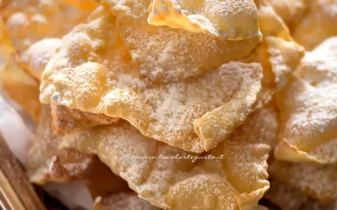 Chiacchiere croccanti, dolci e leggere, come quelle della chiacchiere ricetta della nonna, spolverate di zucchero a velo.