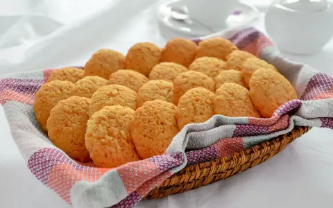 Cesto pieno di biscotti alla cannella, dorati e fragranti, pronti per essere gustati con una tazza di tè.