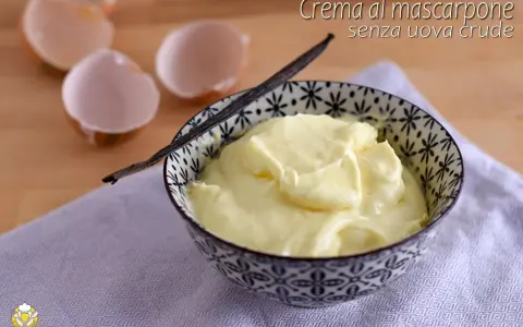 Crema al mascarpone senza uova, soffice e vellutata, pronta per essere gustata. Accompagnata da un baccello di vaniglia e gusci d'uovo vuoti.